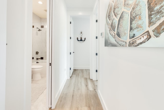 corridor featuring light wood finished floors, recessed lighting, and baseboards