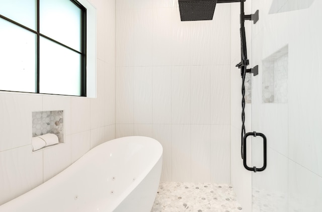 bathroom featuring a freestanding tub, tile walls, and a shower stall