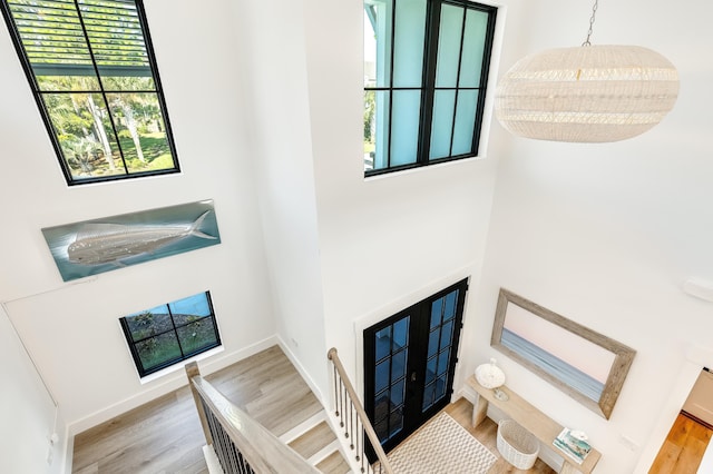 entryway with stairway, wood finished floors, and baseboards