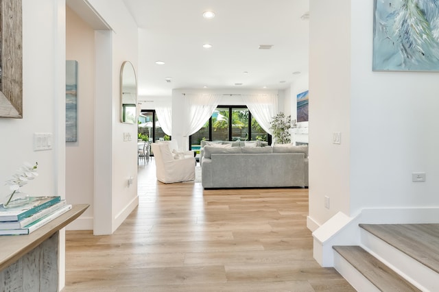 hall featuring recessed lighting, baseboards, and light wood finished floors