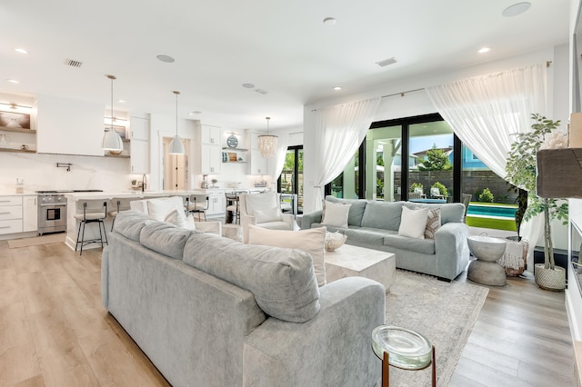 living room with recessed lighting, visible vents, and light wood-style floors