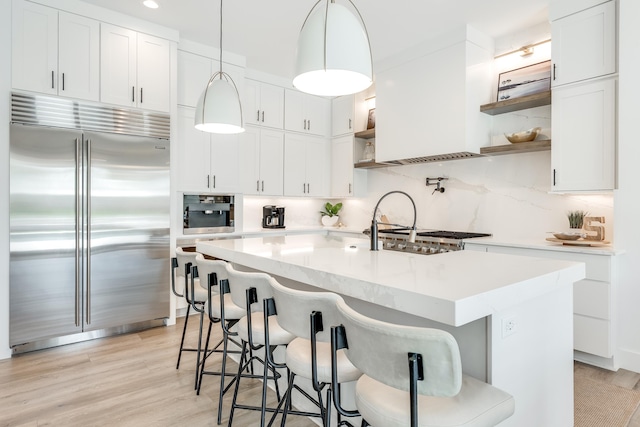 kitchen featuring appliances with stainless steel finishes, light countertops, decorative backsplash, and open shelves