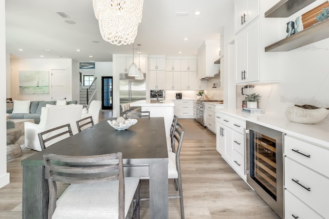 dining room featuring wine cooler, recessed lighting, visible vents, light wood-style floors, and stairs