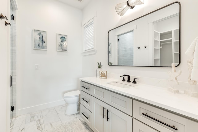 bathroom with toilet, marble finish floor, baseboards, and a shower with door