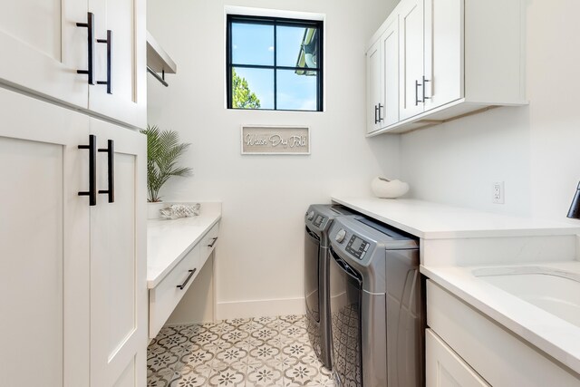 washroom with cabinet space, independent washer and dryer, and baseboards