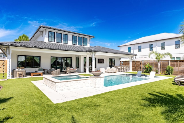 rear view of house featuring an outdoor hangout area, an in ground hot tub, a lawn, and fence