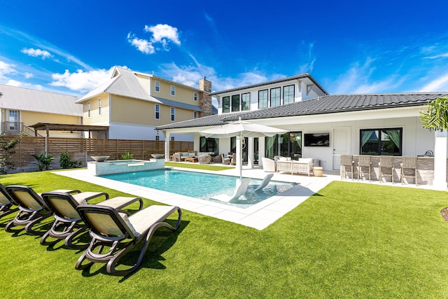 rear view of property featuring a tile roof, a yard, outdoor dry bar, an outdoor hangout area, and a fenced backyard