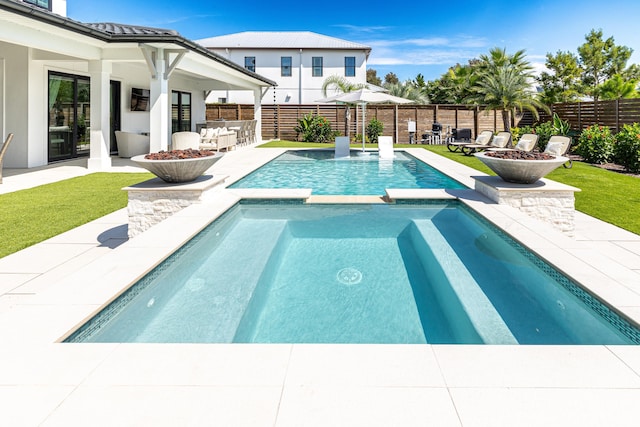 view of swimming pool featuring an outdoor fire pit, a fenced backyard, and a patio