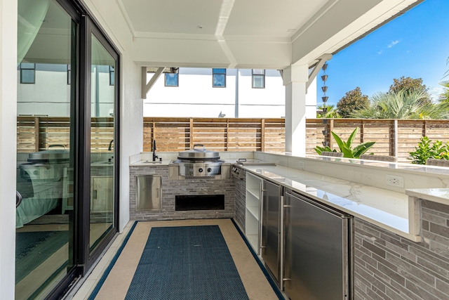 view of patio / terrace featuring a balcony, an outdoor kitchen, and area for grilling