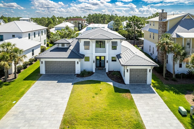 view of front of house with a garage, a tile roof, a residential view, decorative driveway, and a front yard