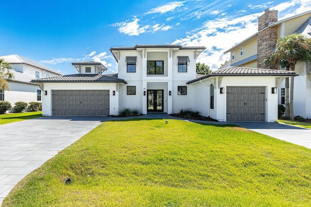 view of front facade featuring french doors, decorative driveway, an attached garage, and a tile roof