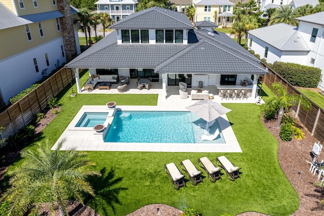 back of property featuring a tile roof, a yard, outdoor dry bar, and a fenced backyard