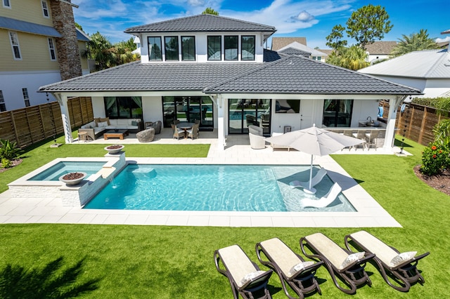 back of house featuring a lawn, an outdoor living space, a patio area, and a swimming pool with hot tub