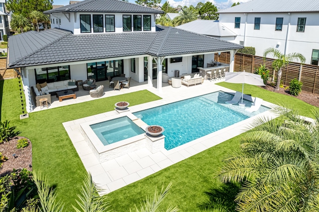 rear view of house with an outdoor hangout area, outdoor dry bar, a fenced backyard, and a tile roof