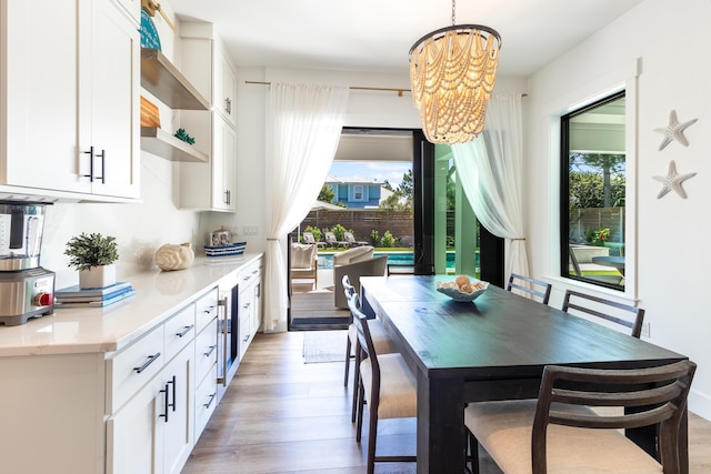 dining room featuring an inviting chandelier, plenty of natural light, and light wood-style flooring