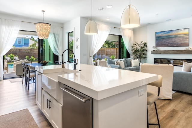 kitchen with open floor plan, stainless steel dishwasher, plenty of natural light, and a sink