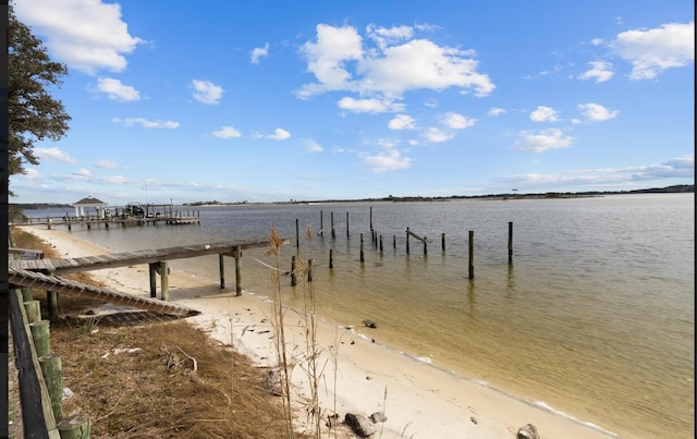 view of dock featuring a view of the beach and a water view