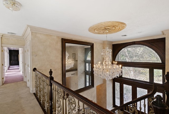 hallway with light carpet, crown molding, and a notable chandelier