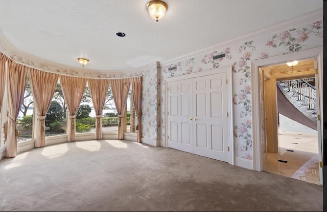 unfurnished bedroom featuring a textured ceiling, light colored carpet, a closet, and access to outside