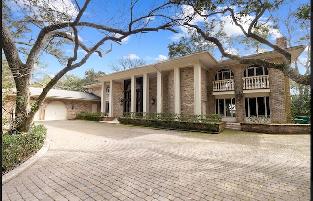 view of front facade featuring a garage and a balcony