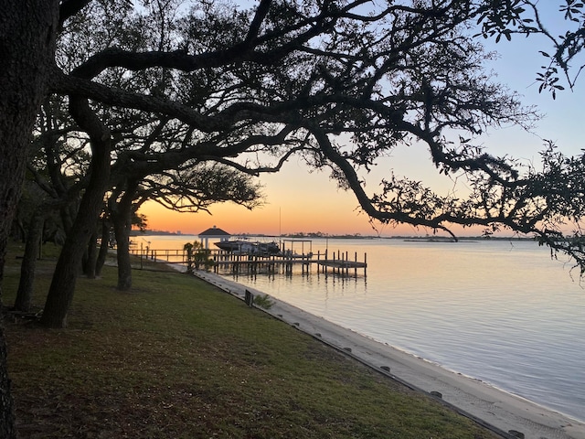 view of dock featuring a water view and a lawn