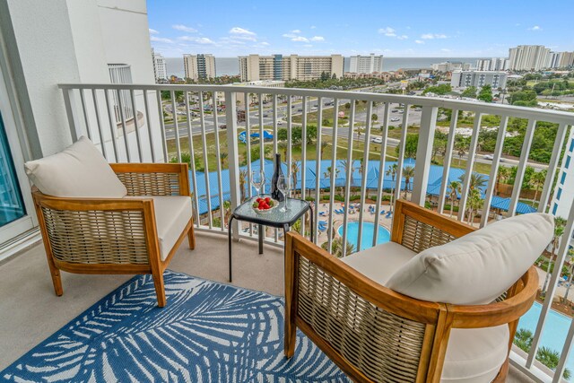 balcony featuring a water view and a swimming pool