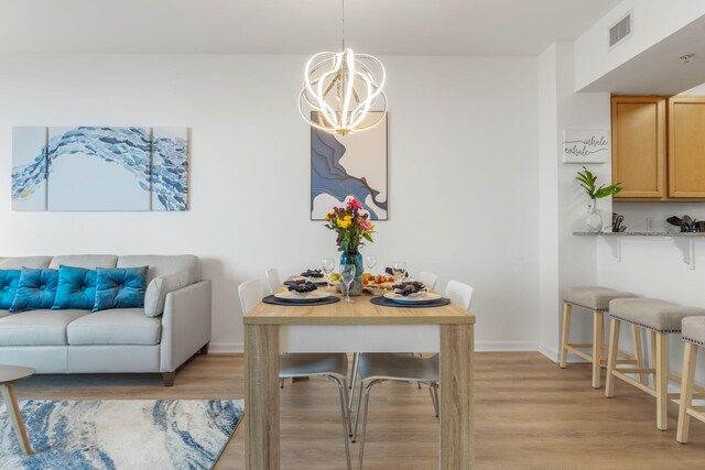 dining area featuring an inviting chandelier and light hardwood / wood-style floors