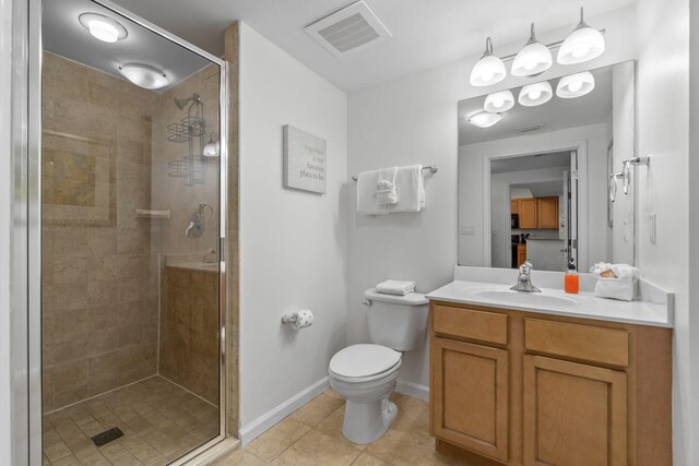 bathroom featuring tile patterned flooring, vanity, toilet, and an enclosed shower