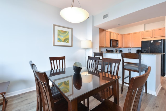 dining area featuring baseboards, visible vents, and light wood-type flooring