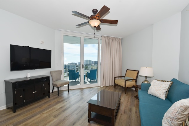 living room featuring ceiling fan, expansive windows, and wood finished floors