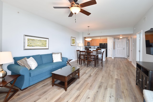 living room with ceiling fan and light hardwood / wood-style floors