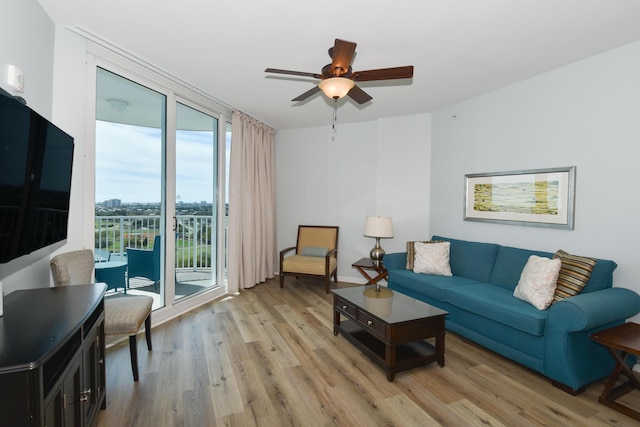 living area with light wood finished floors, ceiling fan, and expansive windows