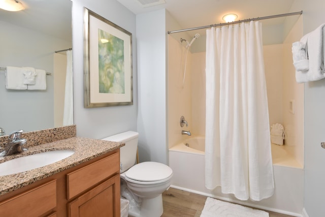 bathroom featuring toilet, wood finished floors, vanity, and shower / bath combination with curtain