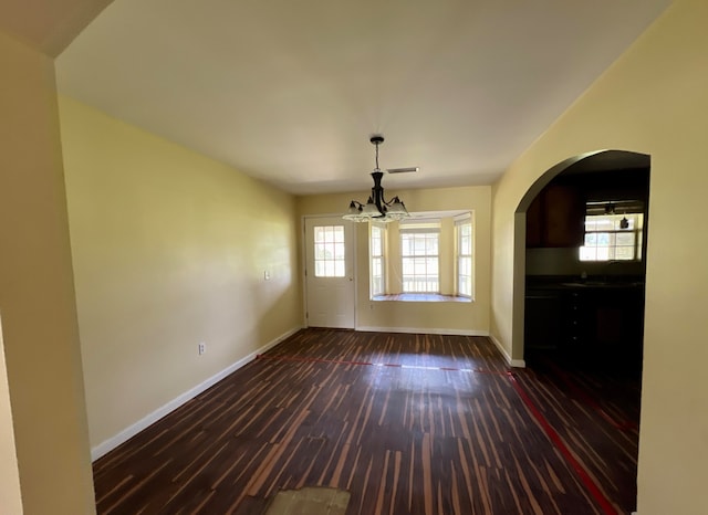 spare room featuring sink, an inviting chandelier, and dark hardwood / wood-style floors