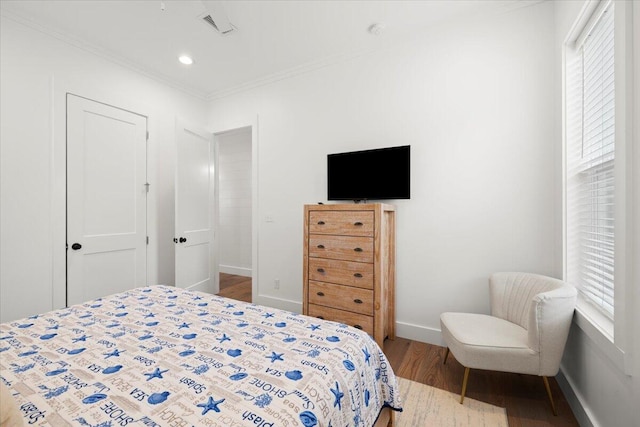 bedroom featuring ornamental molding and light hardwood / wood-style floors