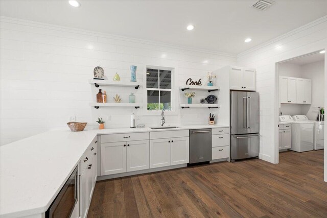 kitchen featuring dark hardwood / wood-style floors, separate washer and dryer, appliances with stainless steel finishes, sink, and white cabinets