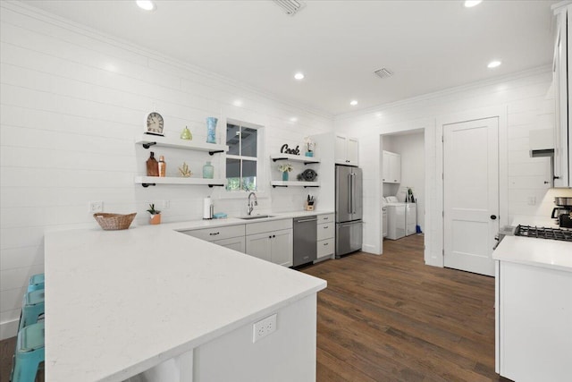 kitchen with separate washer and dryer, dark wood-type flooring, stainless steel appliances, kitchen peninsula, and white cabinets