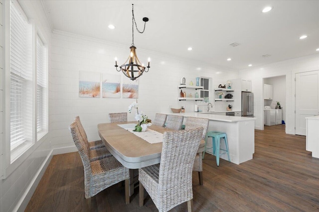 dining area with dark wood-type flooring, plenty of natural light, and a notable chandelier