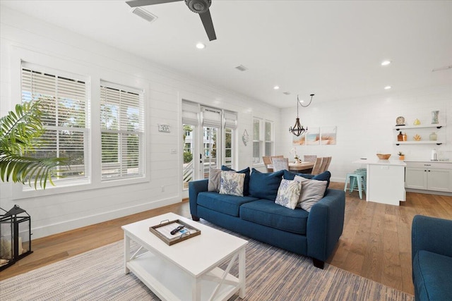 living room with light wood-type flooring and ceiling fan