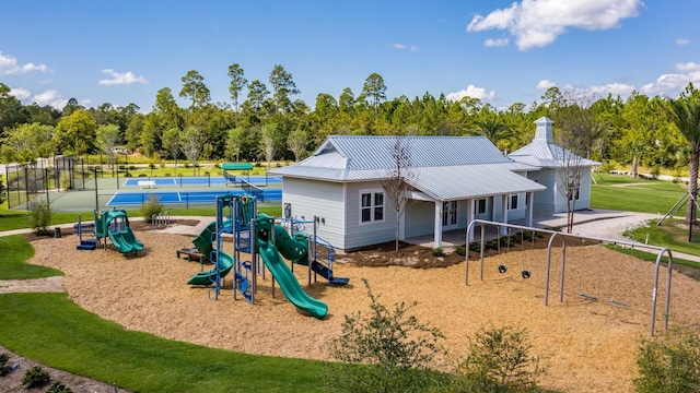 view of jungle gym with a yard and tennis court