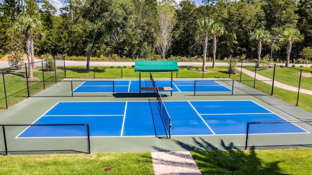 view of tennis court featuring a yard