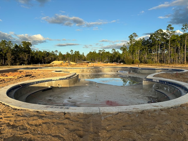 view of swimming pool with a forest view