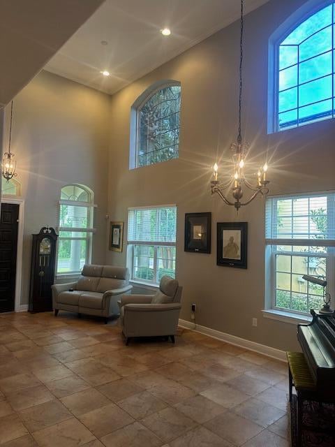 living room featuring a high ceiling, a notable chandelier, and plenty of natural light