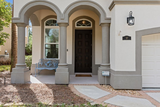 entrance to property featuring a garage and covered porch