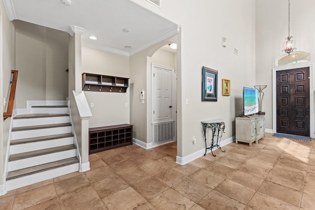 foyer featuring crown molding and an inviting chandelier