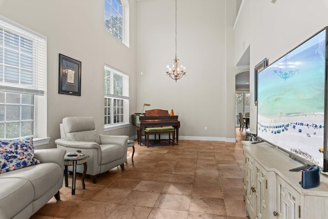 sitting room with a towering ceiling and a chandelier