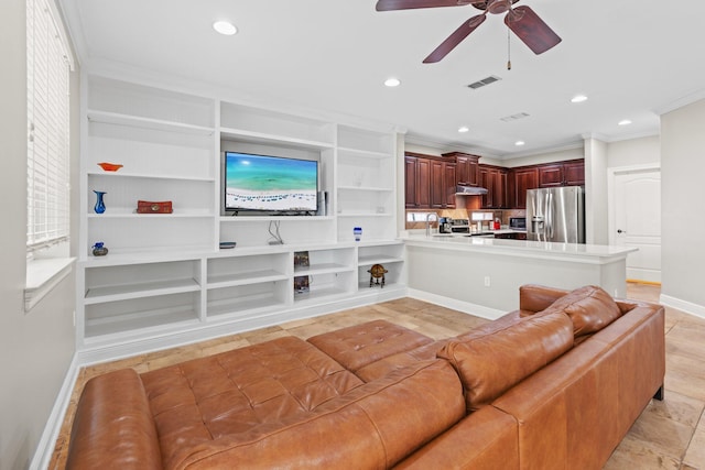 living room featuring ceiling fan, ornamental molding, sink, and built in features