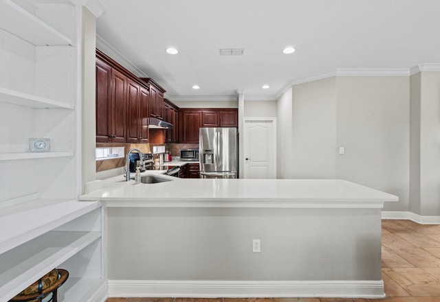 kitchen with crown molding, appliances with stainless steel finishes, sink, and kitchen peninsula