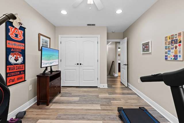 exercise area with light hardwood / wood-style floors and ceiling fan