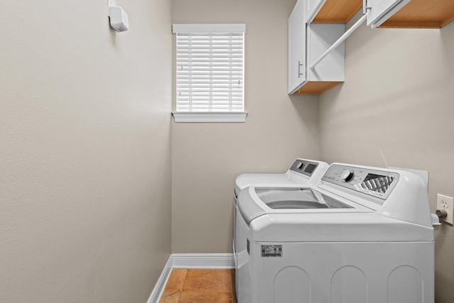 clothes washing area featuring light tile patterned flooring, cabinets, and washer and clothes dryer